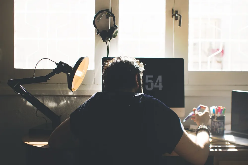 A beige fabric desk chair with a throw blanket in a warm gaming room