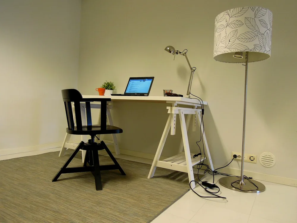 A compact L-shaped desk fitted into the corner of a small room