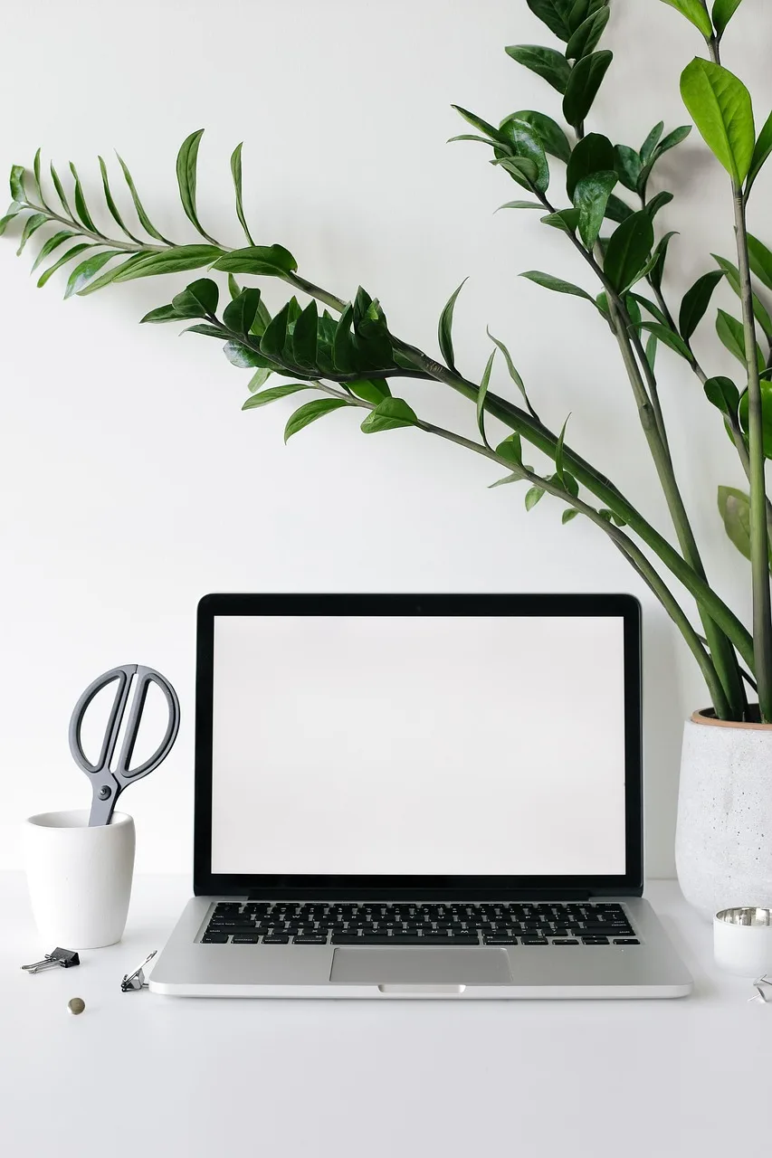 A monitor on an arm floating above an empty walnut desk
