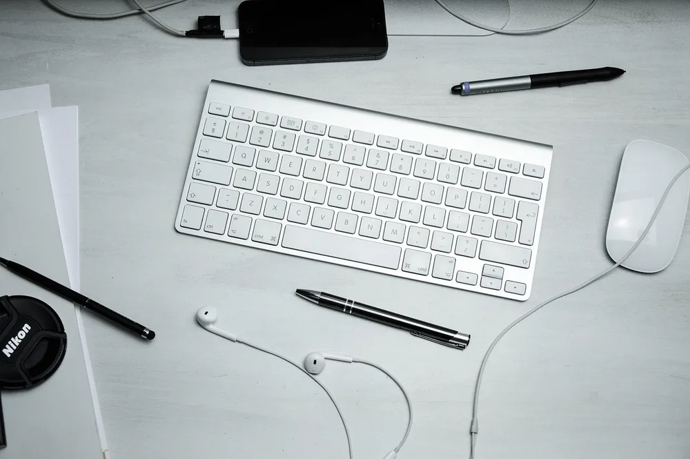 A wireless keyboard and mouse on a gray desk mat with no cables in sight