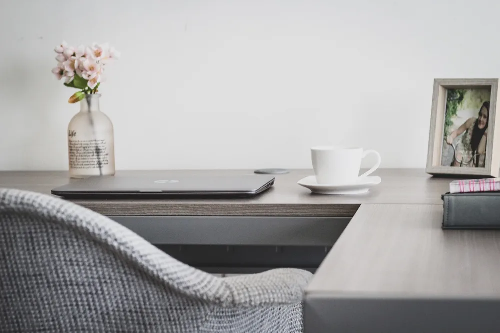 A neutral home office corner in white and light oak tones
