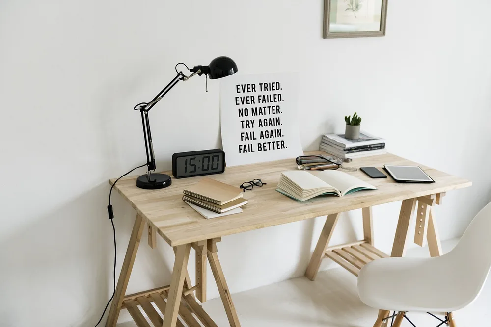 A slim desk lamp casting warm light over an open notebook